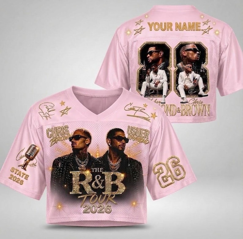 May include: A light pink V-neck jersey featuring a graphic of Chris Brown and Usher with the text The R&B Tour 2026. The back displays the text Your Name, the number 88, and images of the artists. The design includes gold stars, a microphone, and the number 26.