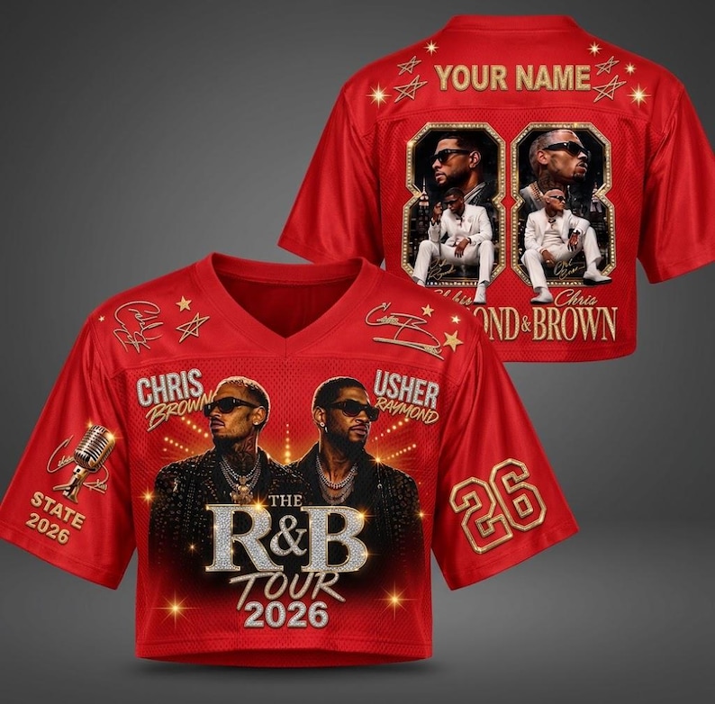May include: A red V-neck jersey featuring graphic prints of Chris Brown and Usher, the text "THE R&B TOUR 2026," "CHRIS BROWN," "USHER RAYMOND," and "STATE 2026." The back displays "YOUR NAME," the number "26," and two framed photos of a performer.