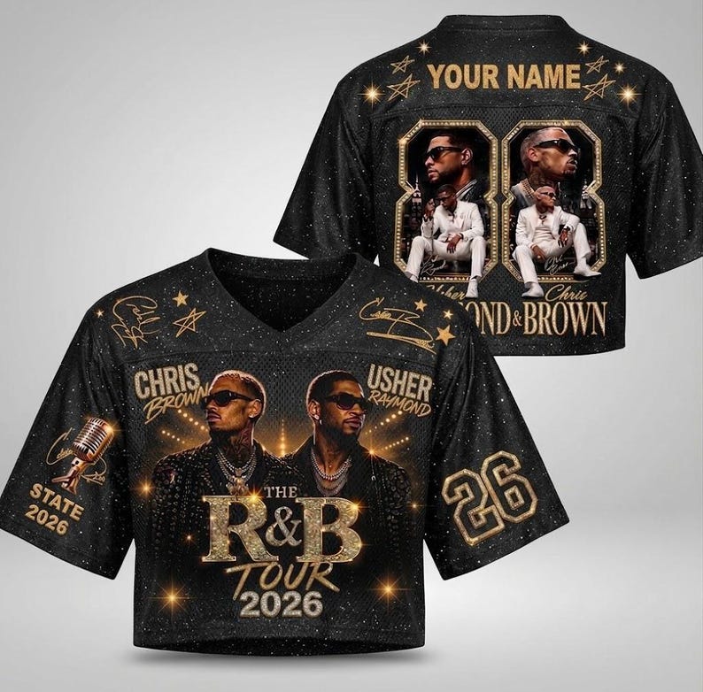 May include: A black short-sleeved jersey featuring gold graphics of Chris Brown and Usher, the text "THE R&B TOUR 2026", "STATE 2026", and the number "26". The back displays "YOUR NAME" with two framed photos of performers in white suits.