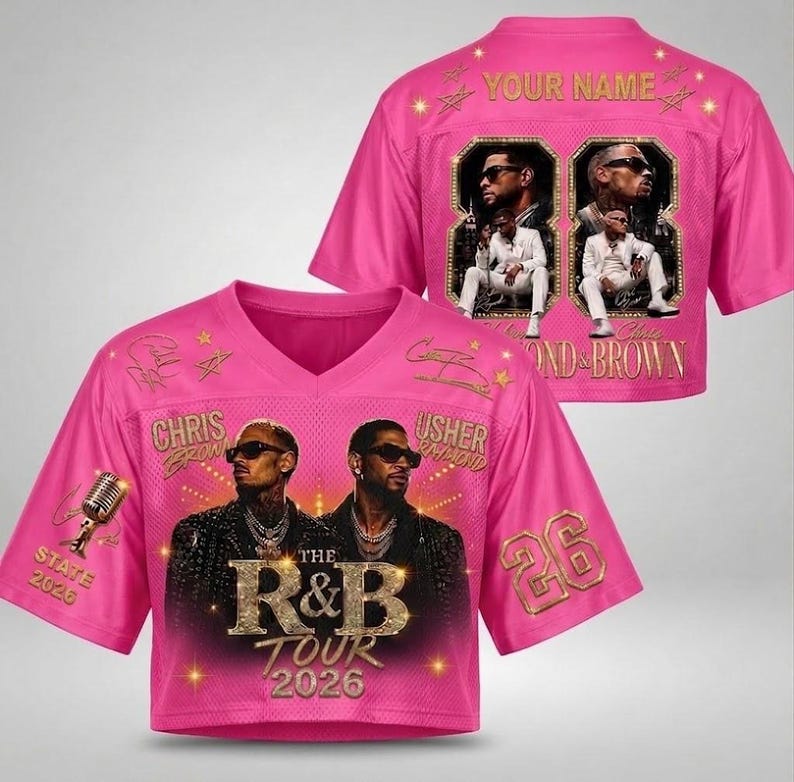 May include: A bright pink V-neck jersey featuring a graphic of Chris Brown and Usher, the text "THE R&B TOUR 2026", a microphone, and the number 26. The back displays "YOUR NAME" above two framed photos of the artists and the text "CHRIS & BROWN".