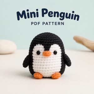 Könnte beinhalten: Ein kleines, rundes, gehäkeltes Pinguin-Spielzeug mit schwarzem Garn an Rücken und Seiten, einem weißen Bauch, zwei schwarzen Augen sowie einem orangefarbenen Schnabel und Füßen. Darüber steht der Text Mini Penguin PDF PATTERN in Dunkelblau.