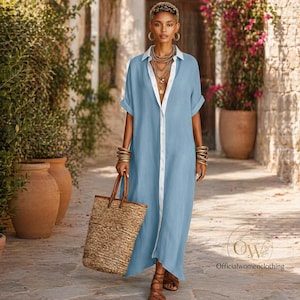Puede incluir: Un vestido largo azul claro con ribete y cuello blancos. El vestido tiene mangas cortas y una botonadura frontal. Una mujer lleva un bolso tote tejido. El vestido forma parte de la línea de ropa de mujer.