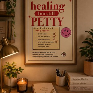 Healing typography printable wall art in a wooden frame above a cozy desk with gratitude journal, candle, books, plants, and warm home office decor for self care and mental wellness.