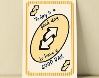 Puede incluir: Una tarjeta rectangular con fondo crema y bordes de rayas amarillas. Presenta un óvalo amarillo central que contiene dos flechas blancas que apuntan en direcciones opuestas. El texto dice: Today is a good day to have a GOOD DAY.
