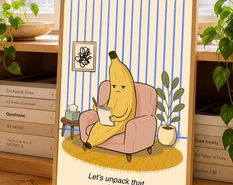 Puede incluir: Una lámina de arte enmarcada con una banana amarilla sentada en un sillón rosa, sosteniendo un bloc de notas y un bolígrafo. El fondo tiene rayas azules verticales, un pequeño cuadro, una caja de pañuelos y una planta. Texto: Let's unpack that. (slowly).