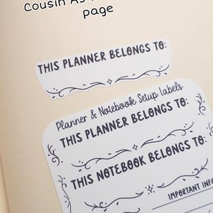 Pode incluir: Etiquetas brancas para configura&ccedil;&atilde;o de planejador e caderno com texto preto e enfeites decorativos. As etiquetas incluem frases como "This Planner Belongs To" e "Start Date". Mostrado em uma p&aacute;gina interna Hobonichi Cousin A5.