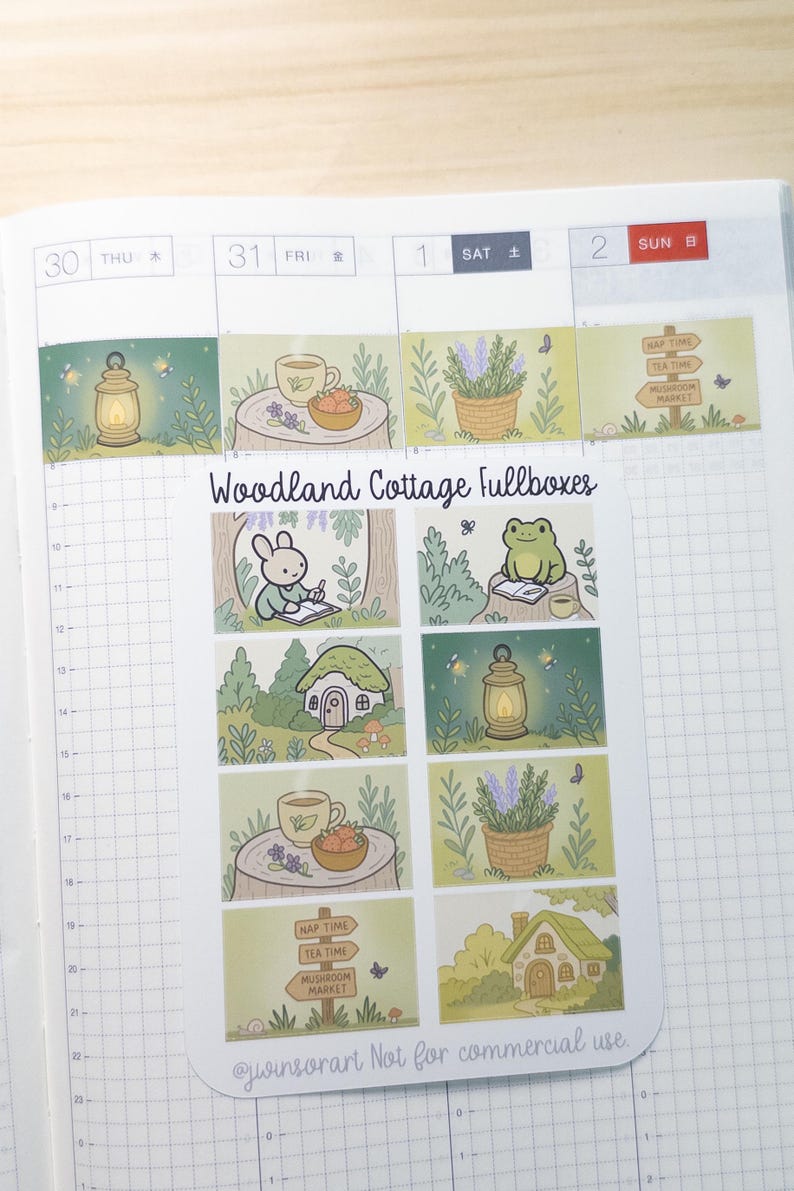 May include: A sheet of planner stickers with a woodland cottage theme. The stickers feature illustrations of a bunny, frog, teacups, lanterns, houses, and signs. The text "Woodland Cottage Fullboxes" is displayed on the sheet.