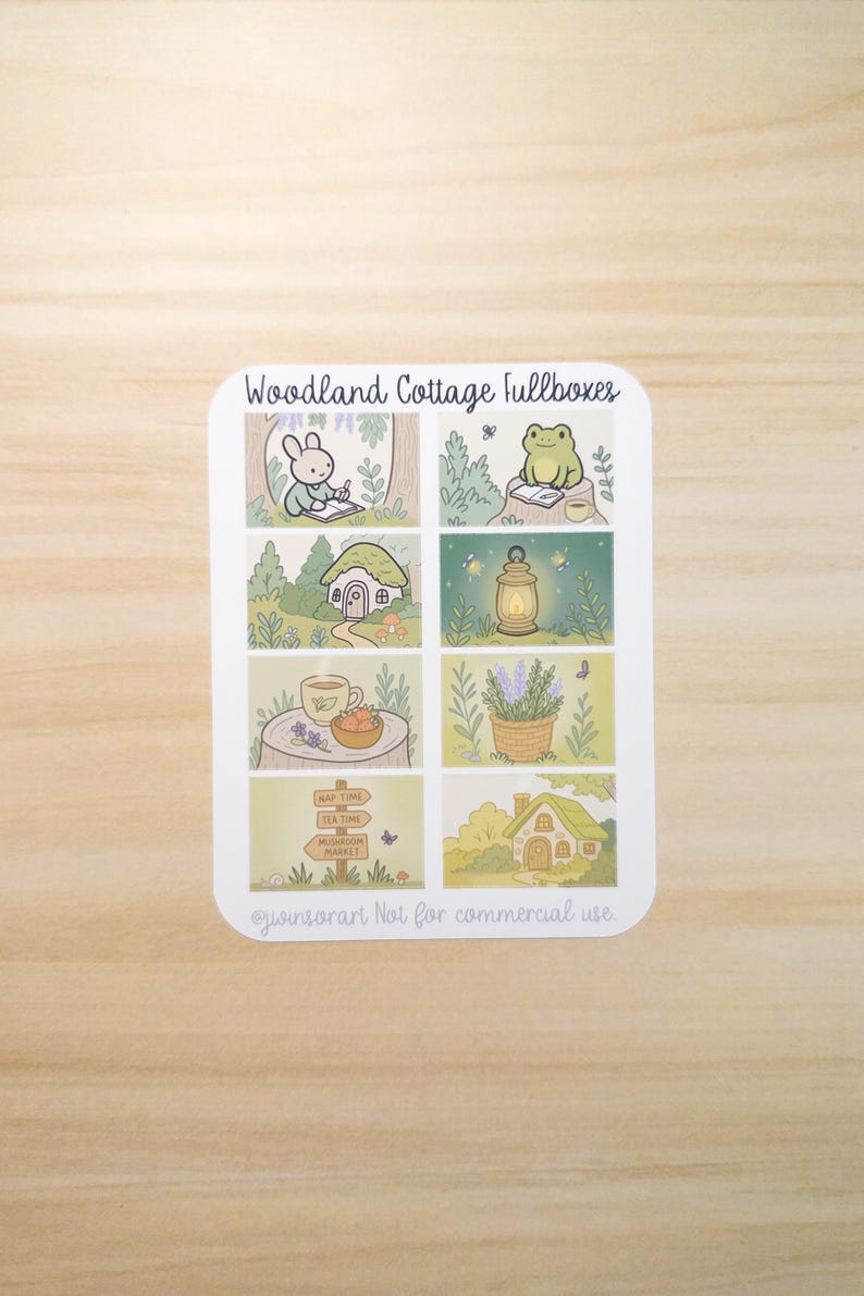 May include: A sticker sheet with the text "Woodland Cottage fullboxes" featuring illustrations of a rabbit, frog, cottage, lantern, tea, lavender, and a signpost. The illustrations are in a soft, pastel color palette.