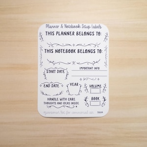 Pode incluir: Uma etiqueta branca para planejador e caderno com texto manuscrito em preto. A etiqueta inclui se&ccedil;&otilde;es para "Este planejador pertence a", "Este caderno pertence a", "Data de in&iacute;cio", "Data de t&eacute;rmino", "Ano" e "Volume".