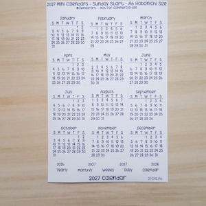 Pu&ograve; includere: Un foglio di carta bianco con un mini calendario 2027 che inizia di domenica, progettato per il formato A6 Hobonichi. Il layout include dodici griglie mensili da gennaio a dicembre, con etichette di testo aggiuntive per le viste annuali e mensili.