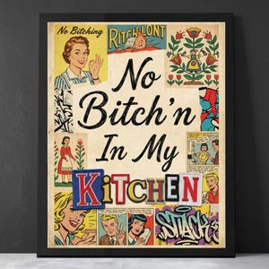 May include: Framed vintage-style print with the text "No Bitch'n In My Kitchen" in a bold font. The artwork incorporates comic book panels and retro illustrations, featuring a woman giving an okay sign and other vintage imagery. The frame is black.
