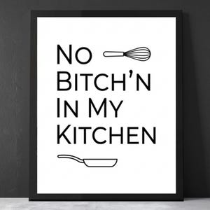 May include: Framed print with the text "NO BITCH'N IN MY KITCHEN" in black, along with line drawings of a whisk and a frying pan. The print is displayed against a dark gray wall.