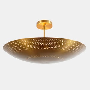 May include: A brass-colored metal pendant light fixture featuring a wide, shallow, bowl-shaped shade. The surface of the shade is covered in a dense pattern of small, circular perforations that allow light to pass through, suspended by a rod.