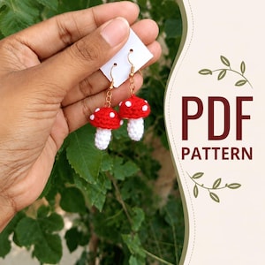 Könnte beinhalten: Gehäkelte Pilzohrringe mit roten Kappen und weißen Punkten und Stielen. Die Ohrringe werden von goldfarbenen Haken gehalten. Das Bild enthält auch den Text "PDF PATTERN".