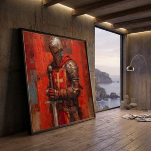 May include: A framed painting of a knight in full armor, holding a sword. The artwork features a red and textured background with the knight's armor in shades of silver and bronze. The knight's shield displays a white cross. The painting is leaning against a concrete wall.
