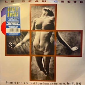 May include: A Guns N' Roses triple vinyl album, limited edition with a French flag colour scheme. The cover shows a nude figure in a grid. Includes Axel Rose tattoos and stickers. Recorded live in Paris, June 6th, 1992.