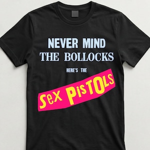 以下が含まれることがあります： 黒いTシャツ。白で「NEVER MIND THE BOLLOCKS」と書かれ、ピンクのバナーの上に「HERE'S THE」と黄色で「Sex Pistols」と書かれています。クラシックなパンクロックデザインです。