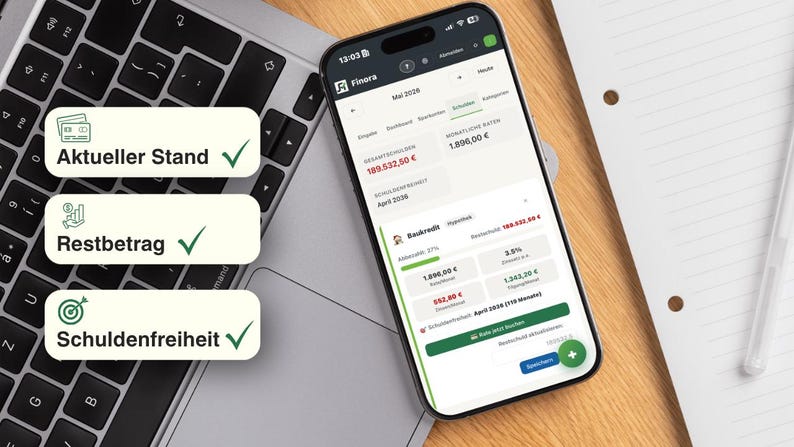 May include: A smartphone displaying a financial app interface, resting on a laptop keyboard. The screen shows account details and financial data. Three labels with German text are visible: "Aktueller Stand", "Restbetrag", and "Schuldenfreiheit". A notepad and pen are in the background.