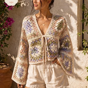 Könnte beinhalten: Ein mehrfarbiges Häkeltop mit Glockenärmeln und einem Bindevorderteil. Das Oberteil hat ein Blumenmuster in Pastelltönen von Rosa, Lila, Grün und Creme. Das Bild zeigt auch beige Shorts und eine kleine gewebte Tasche. Der Text "pdf pattern" befindet sich oben links.
