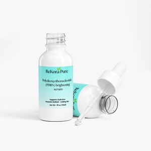 May include: Two white serum bottles with a light blue label that reads "ReKora Pure" and "Polydeoxyribonucleotide (PDRN) brightening serum." One bottle is upright, the other is on its side with the dropper exposed. The bottles contain 1 fl oz (30ml).