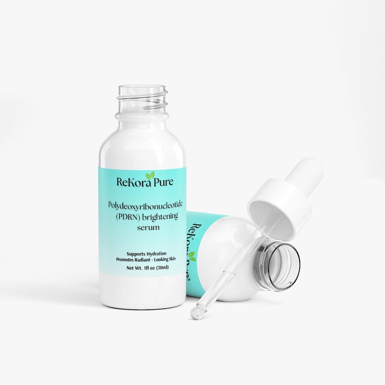 May include: Two white serum bottles with a light blue label that reads "ReKora Pure" and "Polydeoxyribonucleotide (PDRN) brightening serum." One bottle is upright, the other is on its side with the dropper exposed. The bottles contain 1 fl oz (30ml).