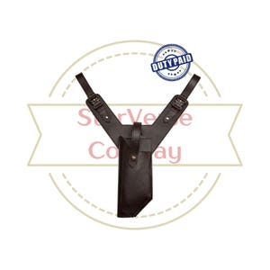 May include: A dark brown leather shoulder holster featuring two adjustable shoulder straps with metal buckles and a central vertical pouch with a snap button closure. The text DUTY PAID is visible in a blue circular stamp at the top right.