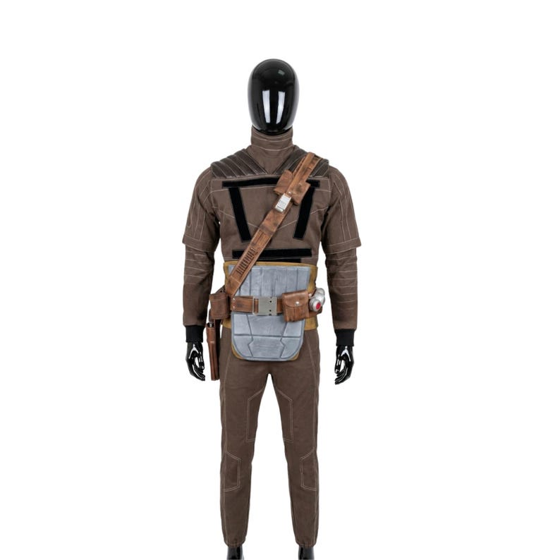May include: A brown costume displayed on a mannequin. The outfit includes a long-sleeved shirt, pants, a utility belt with pouches, and a shoulder strap. The costume has black accents and a silver-colored chest piece.