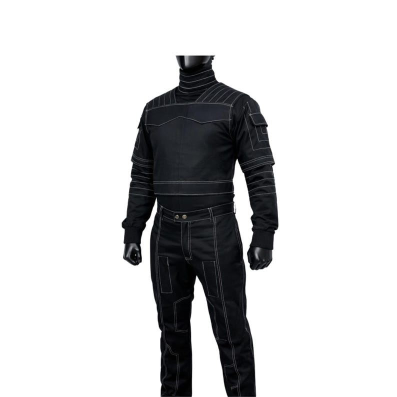 Puede incluir: Mono negro con costuras blancas. El conjunto presenta un cuello alto, m&uacute;ltiples bolsillos y costuras reforzadas. Los pantalones tienen cierre de bot&oacute;n y las mangas tienen costuras reforzadas. El mono se muestra en un maniqu&iacute;.