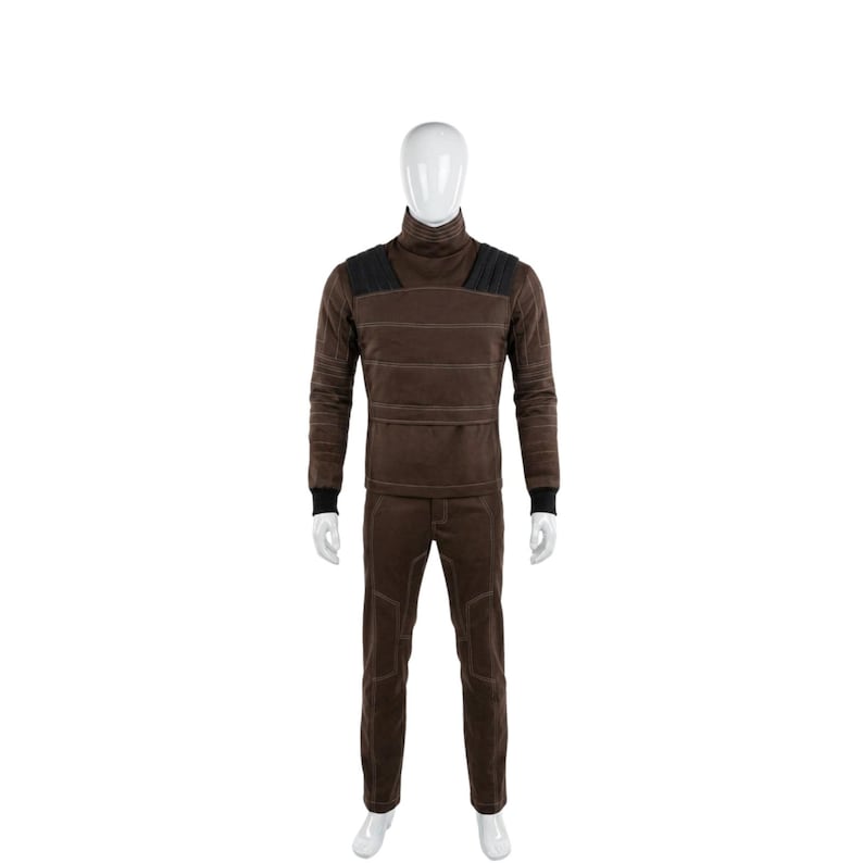 May include: A brown turtleneck long-sleeve shirt and matching pants set. The shirt has black shoulder accents and horizontal stitching. The pants have knee patches. The set is displayed on a mannequin against a white background.
