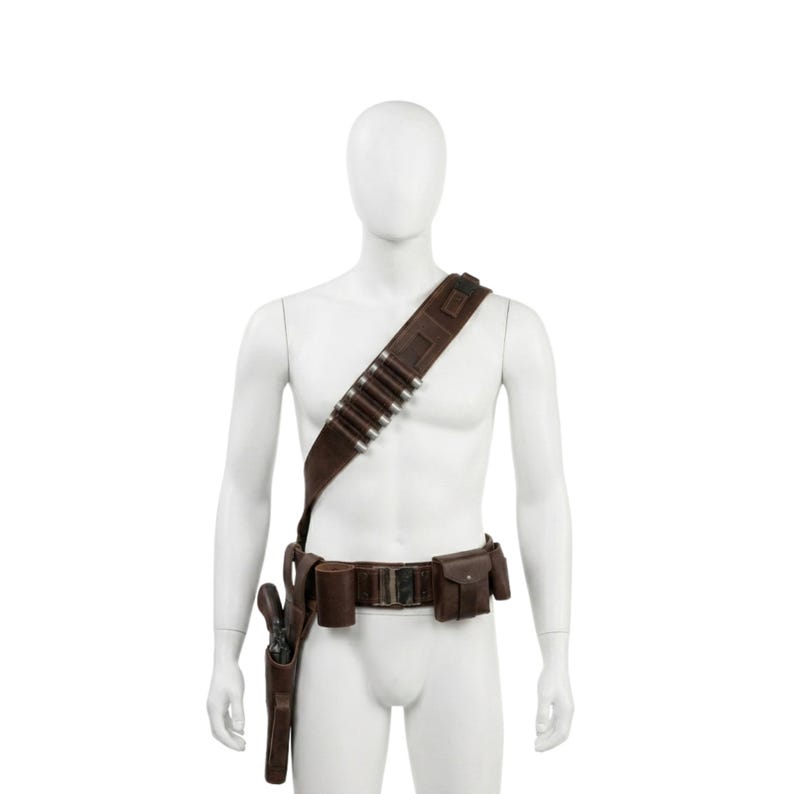 May include: A brown leather bandolier and belt set with a holster and pouches. The bandolier has silver bullet casings. The belt has a buckle and additional pouches. The set is displayed on a mannequin.