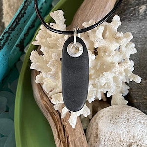 Beach stone jewelry- Black basalt beach stone set with sterling silver grommet.