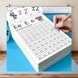 以下が含まれることがあります： 子供向けのアルファベット練習用ワークブック。ページには「Ee」の文字とゾウのイラスト、文字をなぞるための指示が記載されています。一番上のページには「Zz」の文字とシマウマのイラストが描かれています。