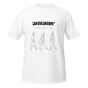 Puede incluir: Camiseta blanca con un diseño gráfico negro. El diseño presenta la palabra "WALKIN'" encima de un dibujo lineal de tres personas caminando. Debajo de la palabra "WALKIN'" está el texto "AIMLESS TRAJECTORY".