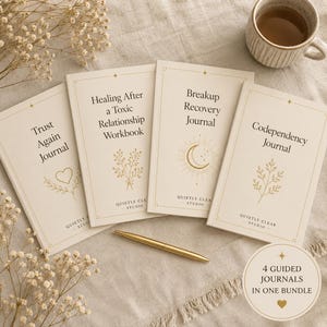May include: Four cream-colored journals with gold text and line art, titled Trust Again Journal, Healing After a Toxic Relationship Workbook, Breakup Recovery Journal, and Codependency Journal, accompanied by a gold pen and a circular label.