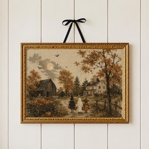 May include: A framed wall art print featuring a rural autumn scene with a barn, a house, and three figures in costumes walking on a path. The artwork includes a full moon, bats, and a wagon filled with pumpkins, all encased in a gold frame with a black ribbon.