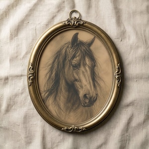 May include: An oval-shaped, antique gold-colored frame with a detailed charcoal drawing of a horse's head. The horse has a long, flowing mane and is centered within the frame. The frame has ornate detailing.