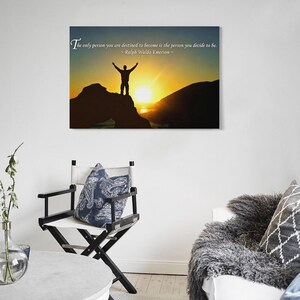 Pode incluir: Impress&atilde;o de arte de parede com uma silhueta de uma pessoa no topo de uma montanha contra um p&ocirc;r do sol. A impress&atilde;o inclui a cita&ccedil;&atilde;o: "A &uacute;nica pessoa que voc&ecirc; est&aacute; destinado a se tornar &eacute; a pessoa que voc&ecirc; decide ser." de Ralph Waldo Emerson.