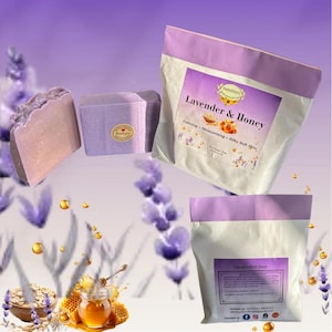 May include: Two bars of lavender-coloured soap, one with a textured top and one with a round sticker, alongside two white pouches with purple trim. The top pouch label reads Lavender & Honey, Calming, Moisturising, Silky Soft Skin, Net Weight 200g.