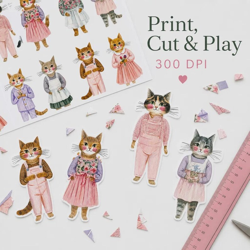 K&ouml;nnte beinhalten: Ein Blatt Papier mit Katzenillustrationen und dem Text Print, Cut & Play 300 DPI, zusammen mit mehreren einzelnen Katzen-Papierpuppen-Ausschnitten in verschiedenen Outfits und einem rosa Lineal mit einer L&auml;nge von etwa 20 cm.