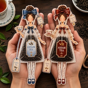 May include: Two tea bags shaped like figures wearing dresses. The left figure has a blue bow and label reading Ceylon Tea. The right figure has a red bow and label reading Assam Tea. Both figures hold a small teacup and have tea leaves inside.