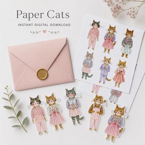 K&ouml;nnte beinhalten: Ein Set aus Paper Cats zum sofortigen digitalen Download, bestehend aus einem hellrosa Umschlag mit goldenem Wachssiegel und mehreren ausgestanzten Illustrationen von anthropomorphen Katzen in gebl&uuml;mten Kleidern und Latzhosen.