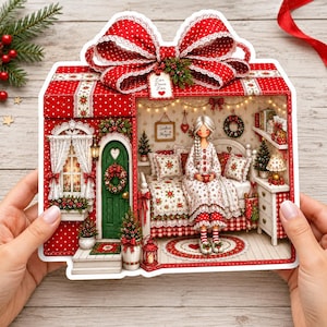 May include: A decorative gift box shaped card featuring a red and white polka dot exterior with a large bow. The interior displays a miniature room scene with a doll sitting on a bed, a green door, a window with white curtains, and a sign reading Lar Doce Lar.
