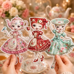 May include: Three die-cut paper dolls featuring anthropomorphic tea-themed characters. The left figure is a pink teapot, the centre is a red teacup, and the right is a green saucer, all wearing floral dresses with intricate patterns and bows.