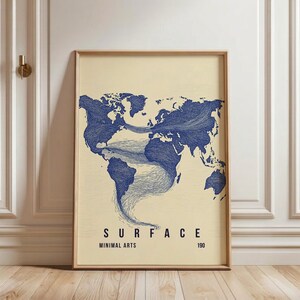 Puede incluir: Un cuadro con una impresión artística de un mapa del mundo. El mapa está representado en azul, con líneas onduladas que conectan los continentes. La palabra "SURFACE" está impresa en negro, junto con "MINIMAL ARTS" y el número "190". El marco es de color madera clara.