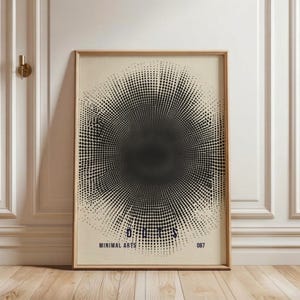 May include: Framed art print featuring a black and white dot pattern forming a circular design. The print includes the word "DOTS" and "MINIMAL ARTS" in a dark blue font. The artwork is displayed in a wooden frame.