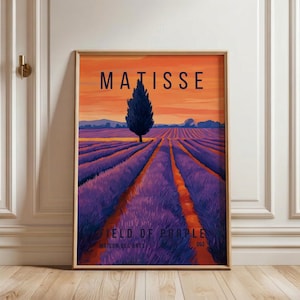 May include: Framed art print featuring a vibrant landscape with a field of purple, a single tree, and the text "MATISSE". The sky transitions from orange to purple. The text "FIELD OF PURPLE" is at the bottom.
