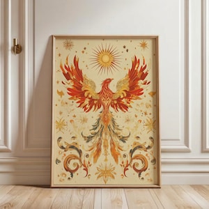 May include: Framed art print featuring a stylized phoenix with outstretched wings. The artwork showcases a vibrant color palette of red, orange, and gold against a cream background. Decorative floral and star elements surround the central phoenix image.