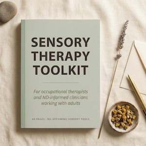 May include: A book titled "SENSORY THERAPY TOOLKIT" with text for occupational therapists and clinicians. The cover is light green with dark text. A sprig of lavender, a small bowl of dried flowers, and a pen are next to the book.