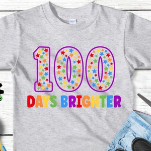 Digital design for crafting svg file for cricut silhouette clip art sublimation. 100 days of school design with a large purple outline 100 with rainbow stars speckled inside. Underneath it says days brighter in all rainbow capital letters.