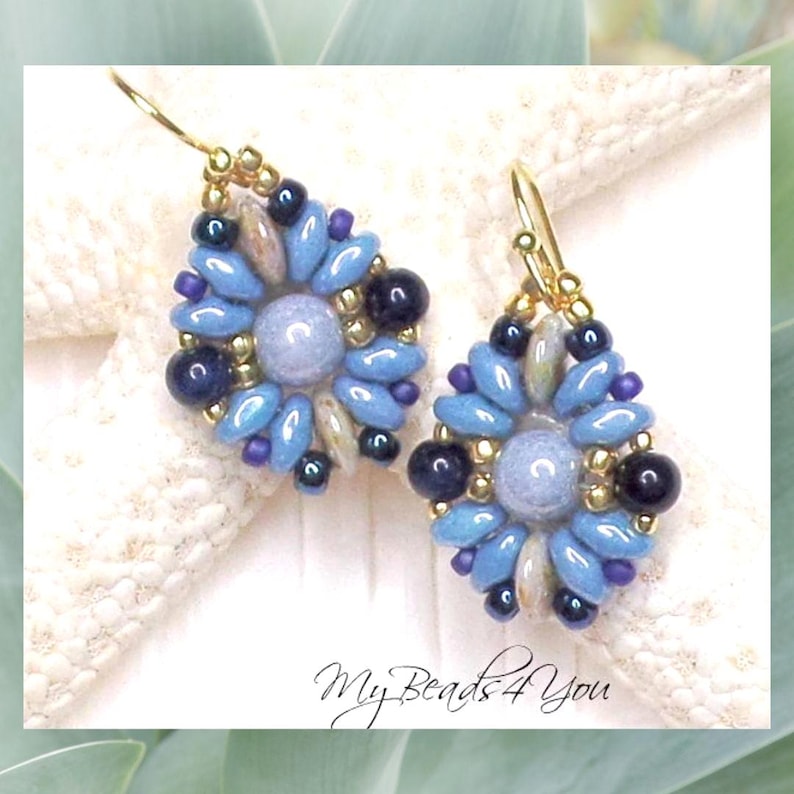 May include: A pair of dangle earrings featuring a central light blue round bead surrounded by a floral pattern of blue petal-shaped beads, dark navy round beads, and small gold-tone seed beads. The earrings hang from gold-tone metal hooks.